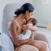 Mother holding baby and kissing its forehead