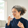Middle aged lady taking antibiotics with water
